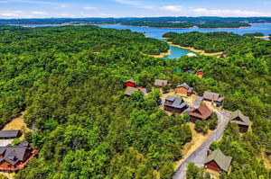 Nestled on a wooded hillside overlooking a serene lake, this peaceful property offers stunning natural surroundings with mountains framing the horizon—an ideal lakeside retreat.