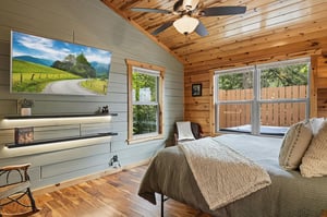 Your private retreat features natural wood ceilings and large sliding doors opening to a quiet outdoor deck, perfect for morning coffee or evening relaxation.