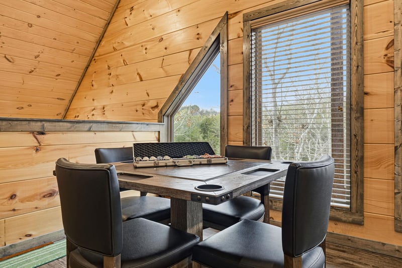 Settle into this cozy woodlined dining nook where warm timber surrounds you and large windows frame peaceful forest views for memorable meals.