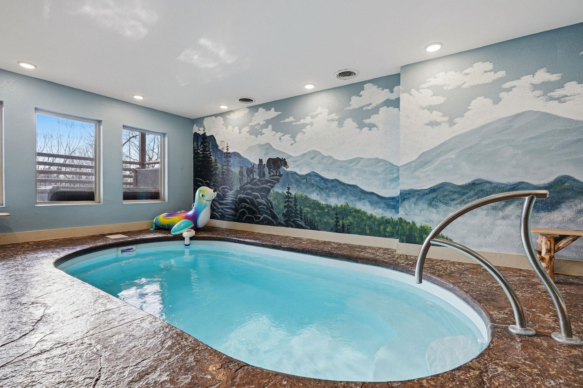 Dive into your private mountain oasis, where crystalclear waters await beneath a stunning wilderness mural.
