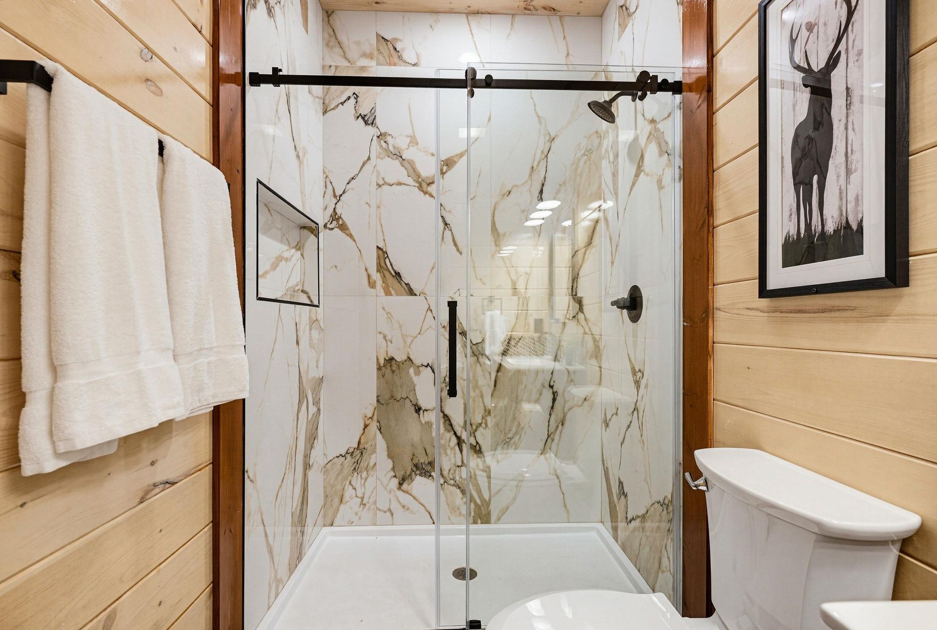 Refresh yourself in this beautifully appointed bathroom, featuring a luxurious marbletiled shower with sleek glass doors and warm wood accents.