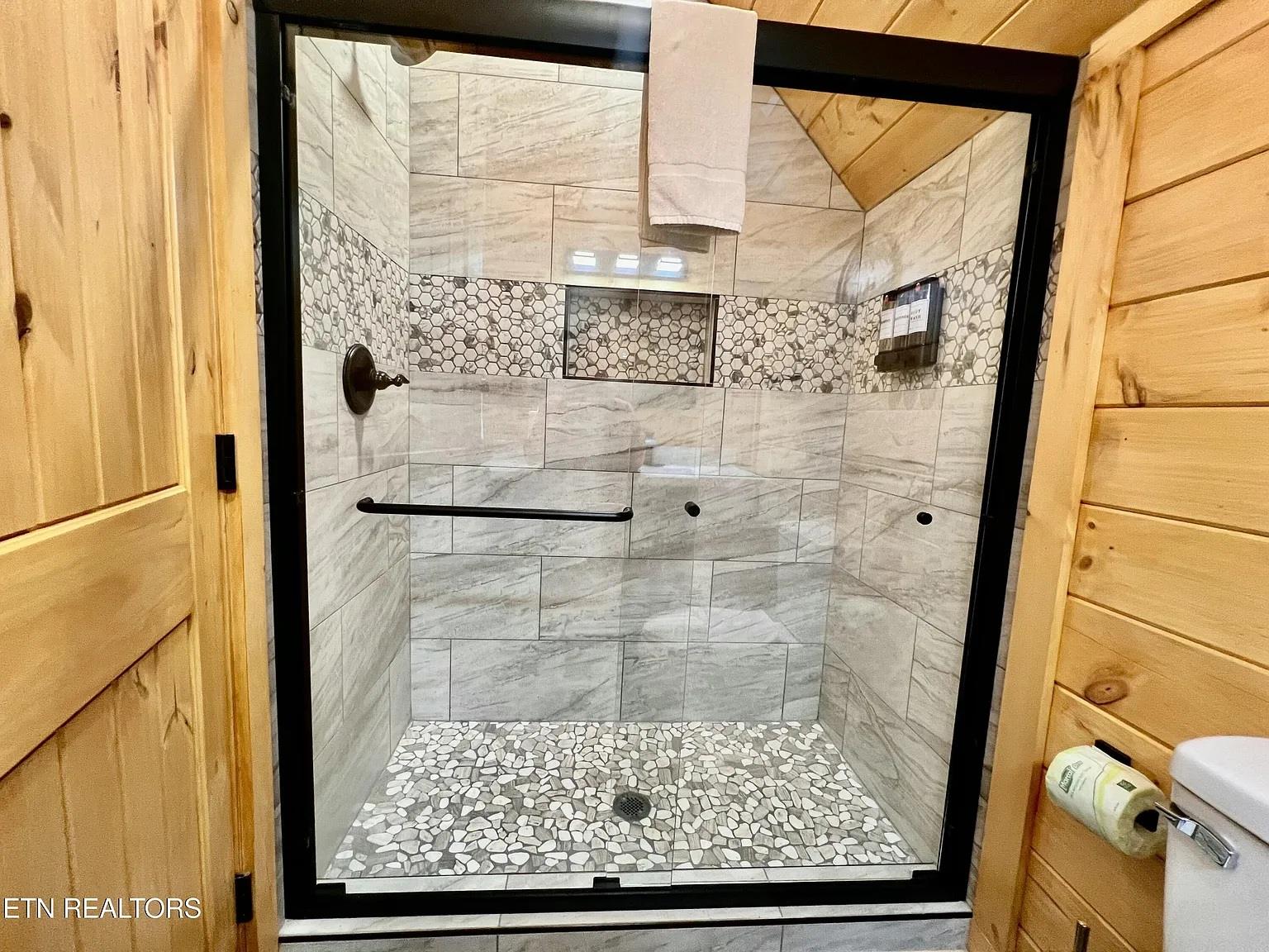Step into your luxurious walkin shower featuring stunning marble tiles and elegant mosaic accents that create a spalike retreat.