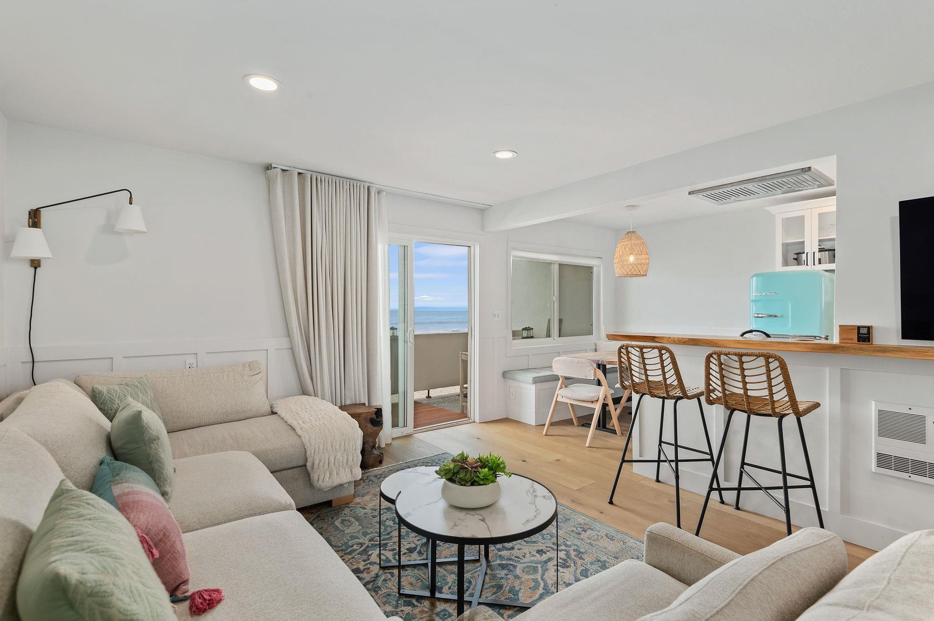 Living room with sectional sofa, breakfast bar, flat screen TV and ocean views.