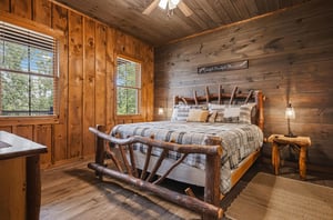Drift off to sleep in this cozy rustic bedroom, where warm wood tones and a handcrafted log bed create your perfect mountain retreat. Natural light streams through windows framing forest views.