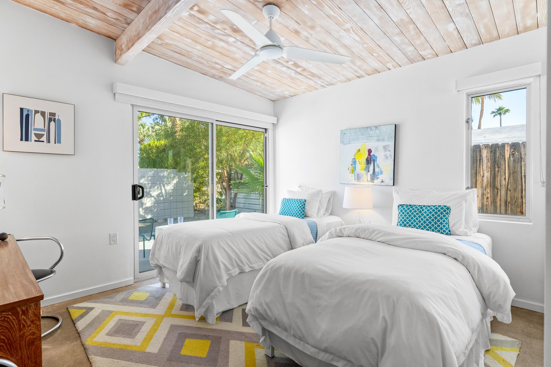 Rest in your bright twin bedroom with stunning exposed wood beams and peaceful garden views through expansive windows.