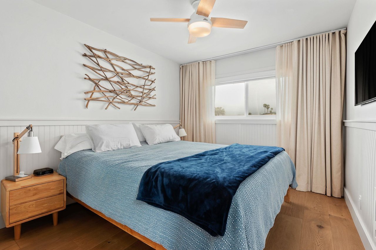 The master bedroom has a California King, flat screen TV, shades, curtains, and a ceiling fan.