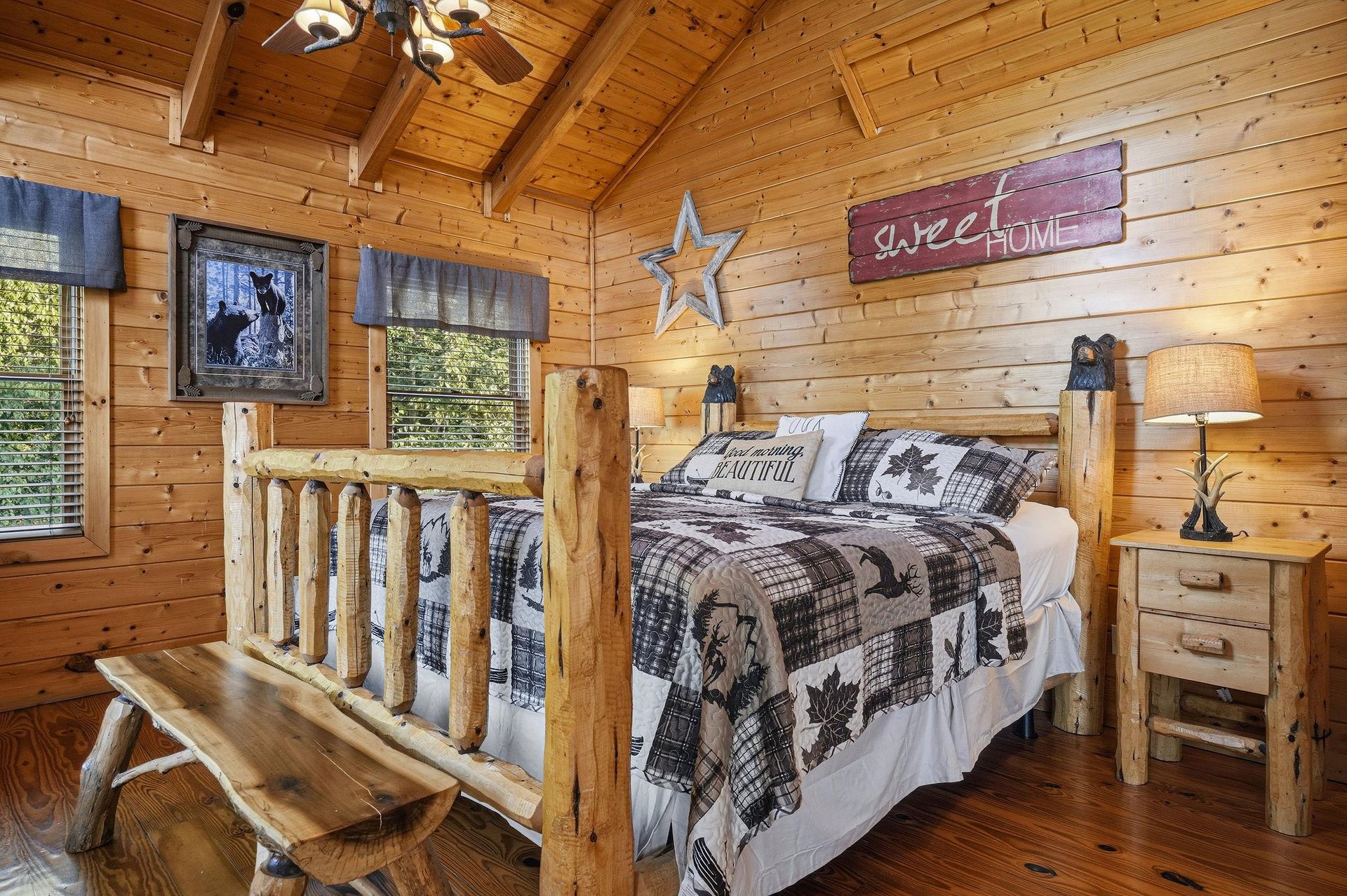 Step into your cozy log cabin bedroom with soaring vaulted ceilings and warm wood surrounding you. Your handcrafted log bed invites restful mountain nights beneath rustic charm.