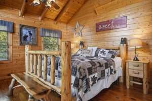 Step into your cozy log cabin bedroom with soaring vaulted ceilings and warm wood surrounding you. Your handcrafted log bed invites restful mountain nights beneath rustic charm.