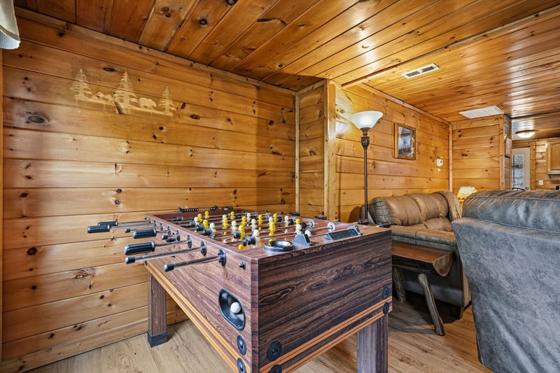 Challenge friends to foosball matches in your cozy game room, complete with leather seating and warm cabin vibes.