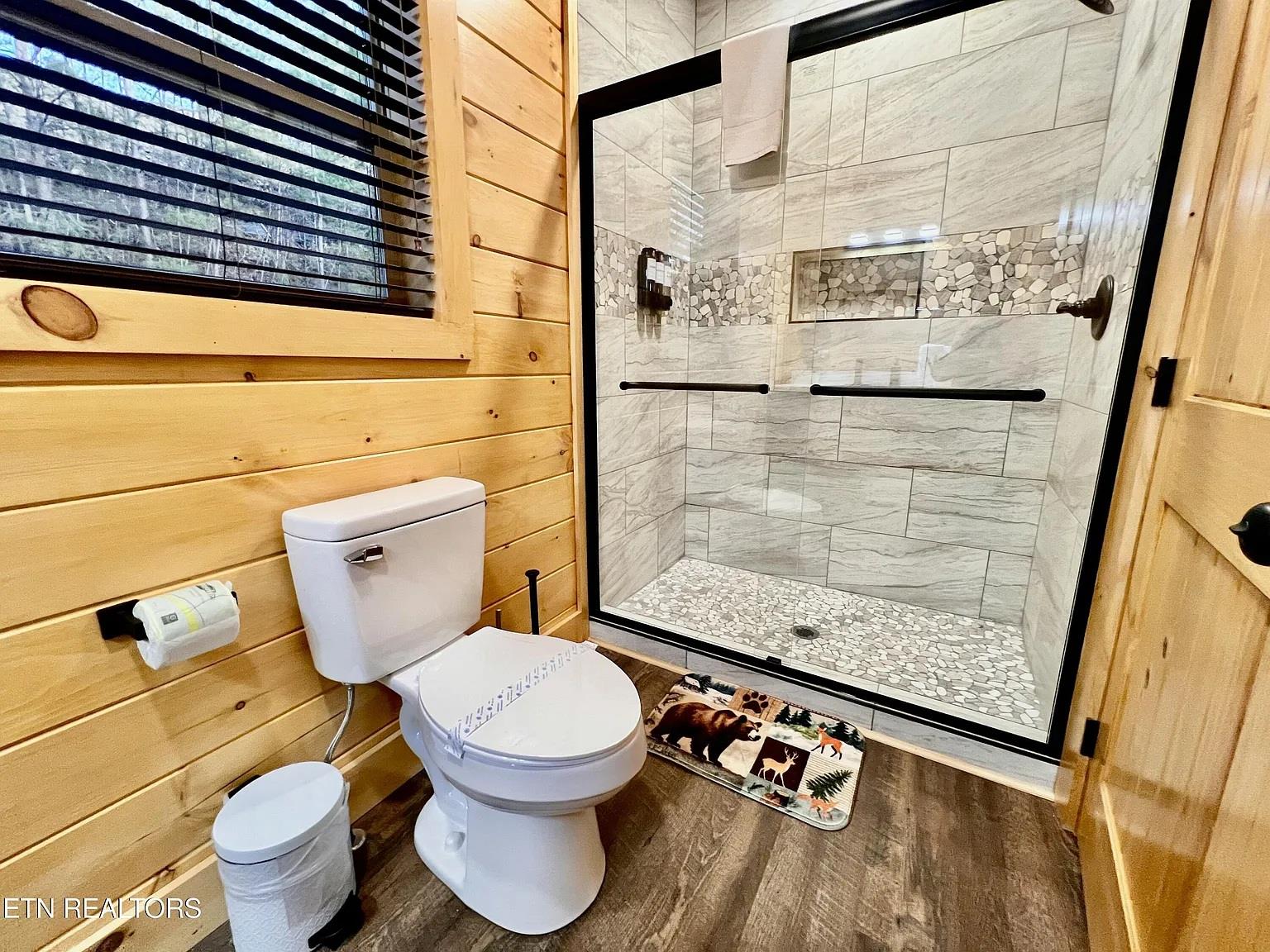 Step into your private spalike retreat with rustic wood walls and luxurious stone shower featuring elegant tile work.