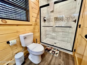 Step into your private spalike retreat with rustic wood walls and luxurious stone shower featuring elegant tile work.