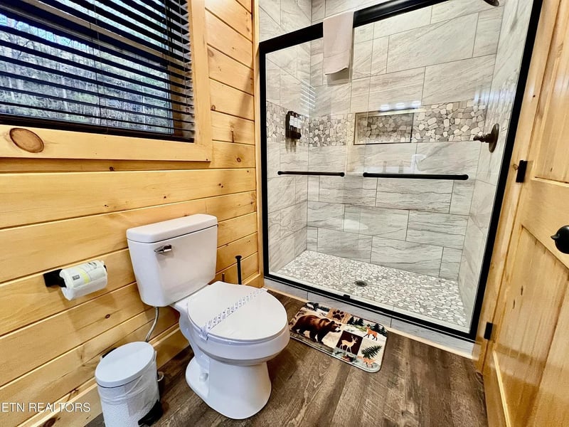 Step into your private spalike retreat with rustic wood walls and luxurious stone shower featuring elegant tile work.