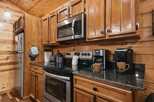 Warm wood surrounds your fully equipped kitchen, complete with modern appliances and a coffee maker for your morning brew.