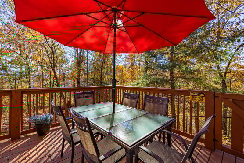 Deck dining with umbrella at Buena Vista Getaway, a 3 bedroom cabin rental located in gatlinburg