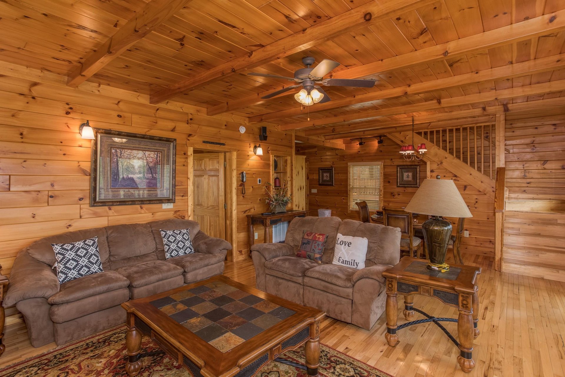 A sofa and loveseat in the living room at Howlin in the Smokies, a 2 bedroom cabin rental located in Pigeon Forge