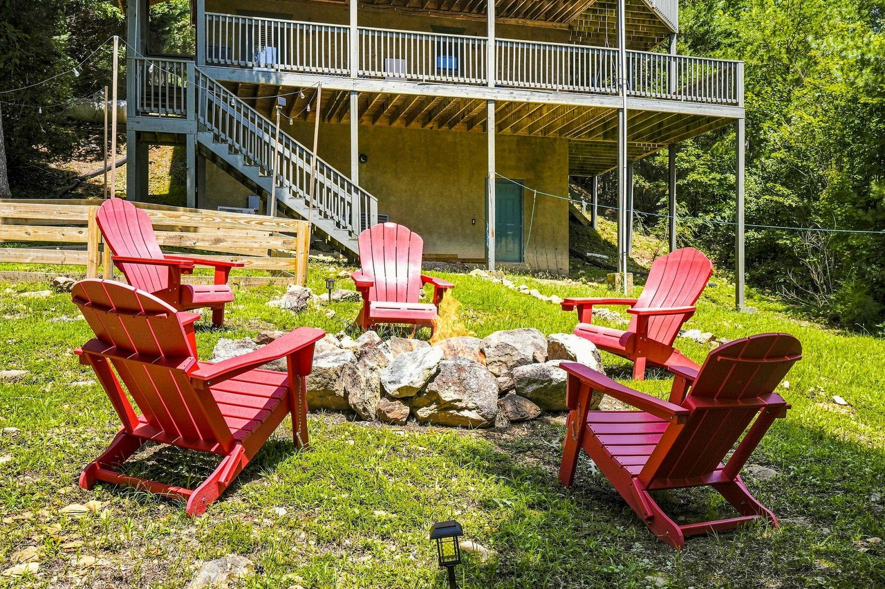Gather around the stone fire pit in bright red Adirondack chairs, perfect for evening conversations under the stars.