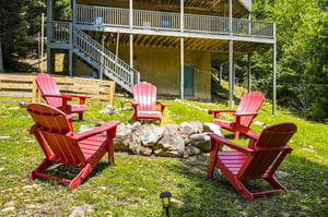 Gather around the stone fire pit in bright red Adirondack chairs, perfect for evening conversations under the stars.