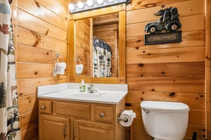 Step into your cozy cabin bathroom, where rustic wood walls meet playful touches like the charming Bear With Me sign. Youll find fresh towels, warm lighting, and welcoming woodland decor that make 