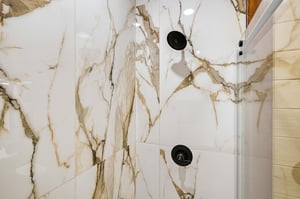 Step into a spalike shower wrapped in gorgeous marblelook tile. The gold veining adds natural elegance, while modern fixtures ensure your morning rinse is as beautiful as it is refreshing.