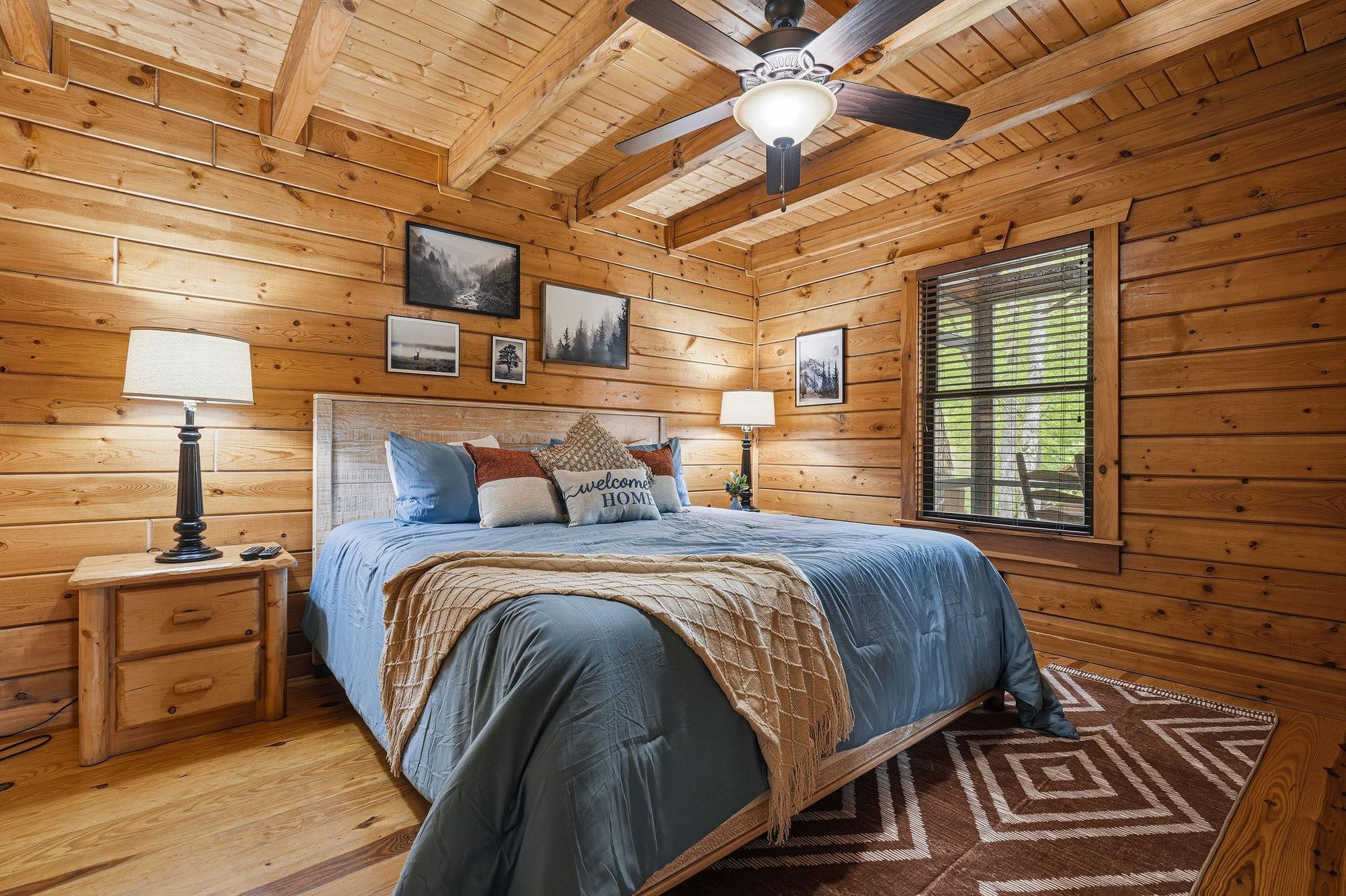Cozy log cabin bedroom where youll sleep soundly under rustic exposed beams, surrounded by warm wood walls and nature artwork.
