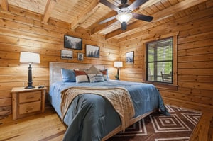 Cozy log cabin bedroom where youll sleep soundly under rustic exposed beams, surrounded by warm wood walls and nature artwork.