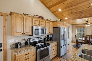 Your fully equipped kitchen features granite counters, stainless appliances, and warm wood cabinets perfect for preparing meals together.