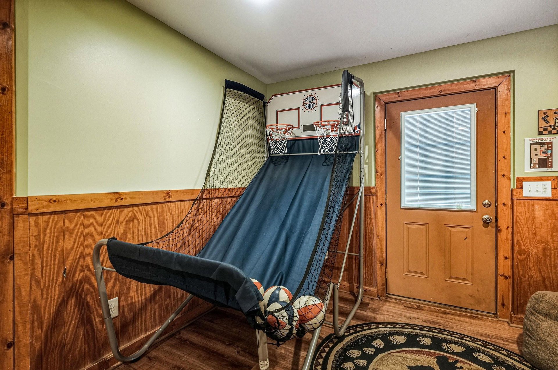 Challenge your friends to a basketball shootout in this fun game room with rustic wood paneling and cozy cabin charm.