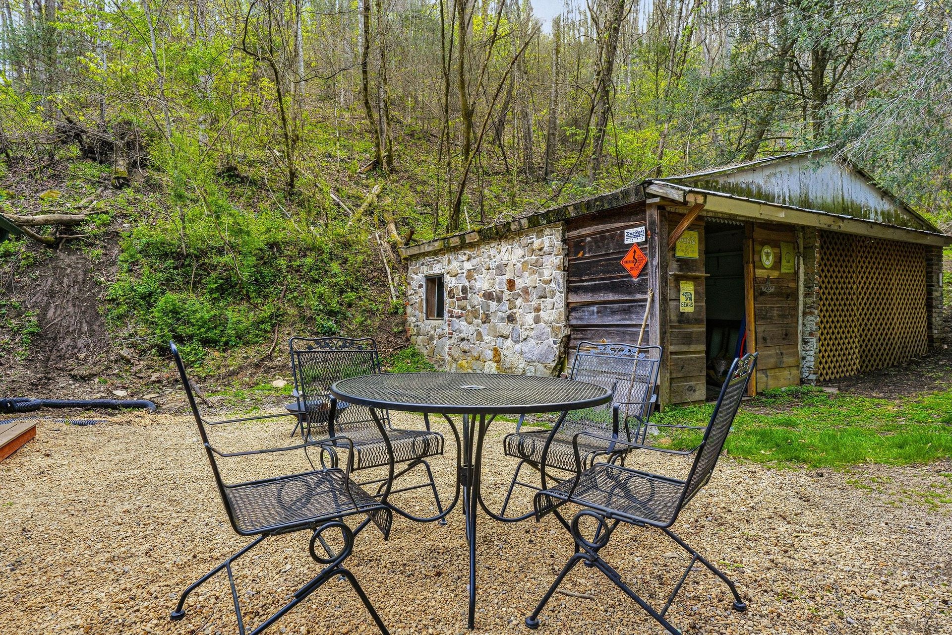 Rustic stone and wood cabin nestled in peaceful woodland setting with outdoor dining area for forest retreats.