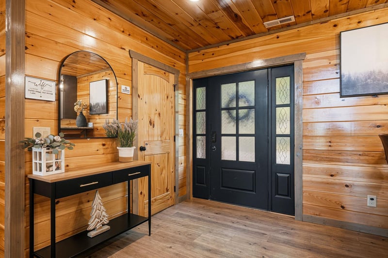 Step into your cozy mountain retreat through elegant French doors, where rustic log walls and thoughtful touches create an instantly welcoming atmosphere.