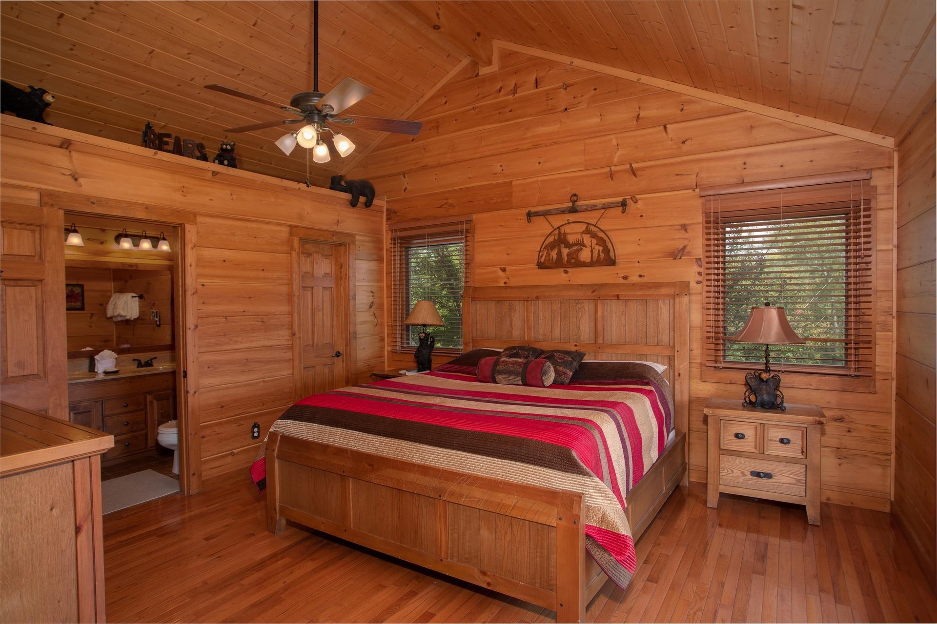 Bedroom with a kingsized wooden bed and vaulted ceilings at Cedar Creeks, a 2bedroom cabin rental located near Douglas Lake