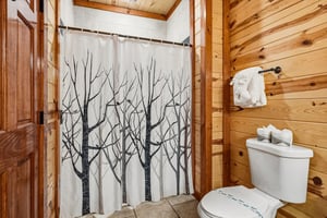 Refresh in your rustic bathroom with warm wood walls and a natureinspired shower curtain that brings the outdoors in.