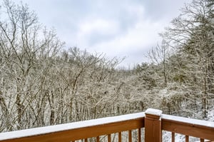 Snowcovered balcony overlooking a winter forest landscape with frostkissed trees.
