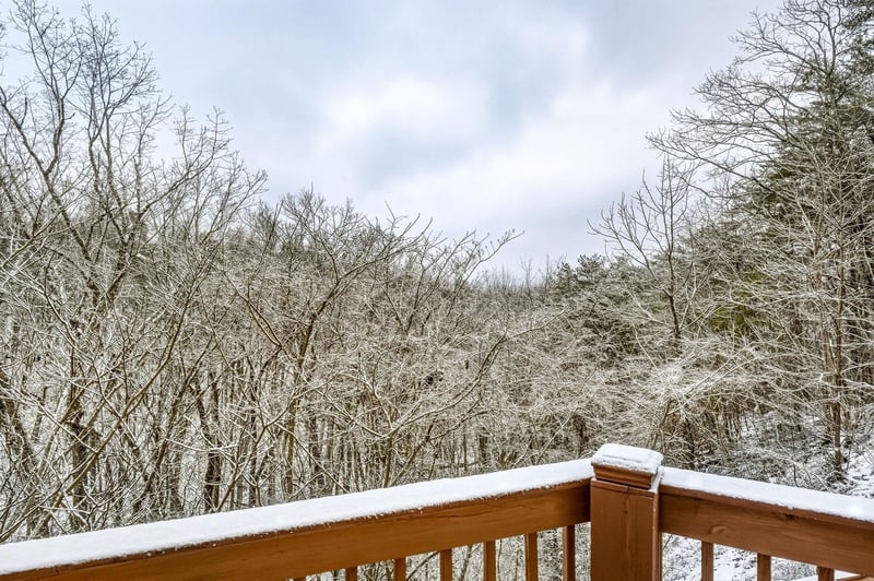Snowcovered balcony overlooking a winter forest landscape with frostkissed trees.