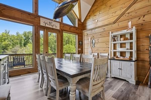 Gather around your rustic dining table where warm wood beams frame forest views through floortoceiling windows—perfect for memorable meals together.