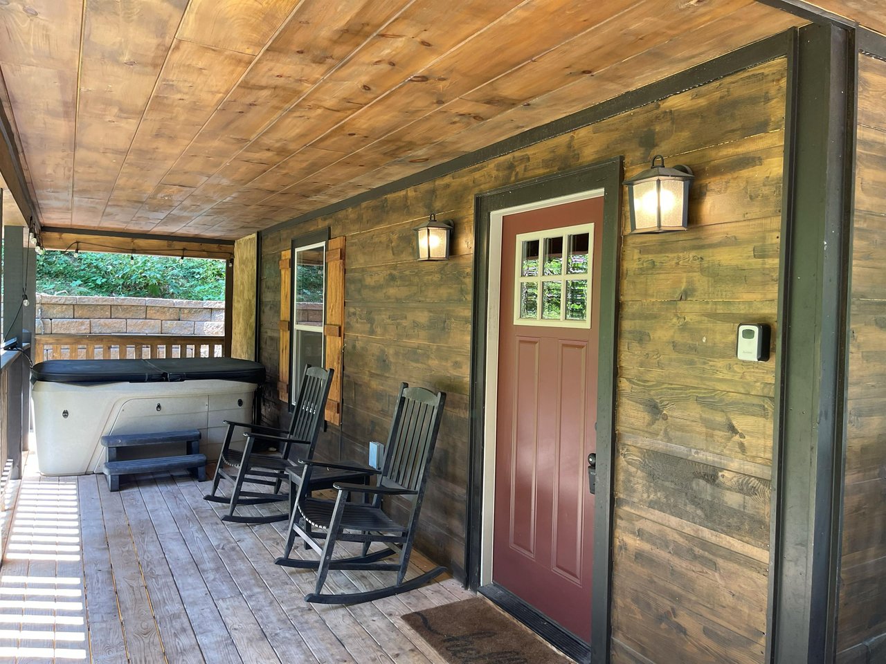 Covered porch with a hot tub and rocking chairs where you can unwind and enjoy the peaceful surroundings.