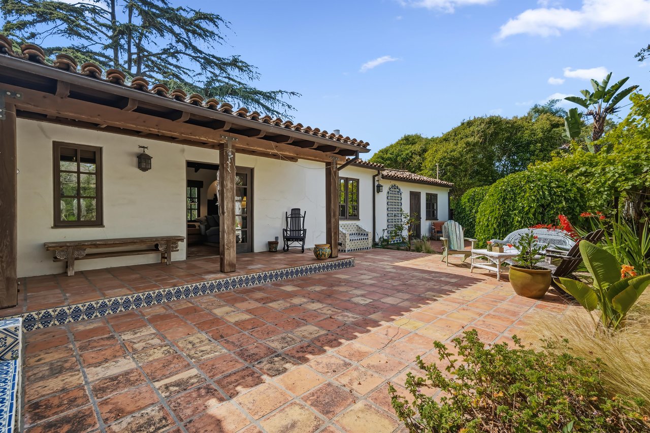 Stunning patio with mosaic tiles, outdoor seating, and an outdoor shower.