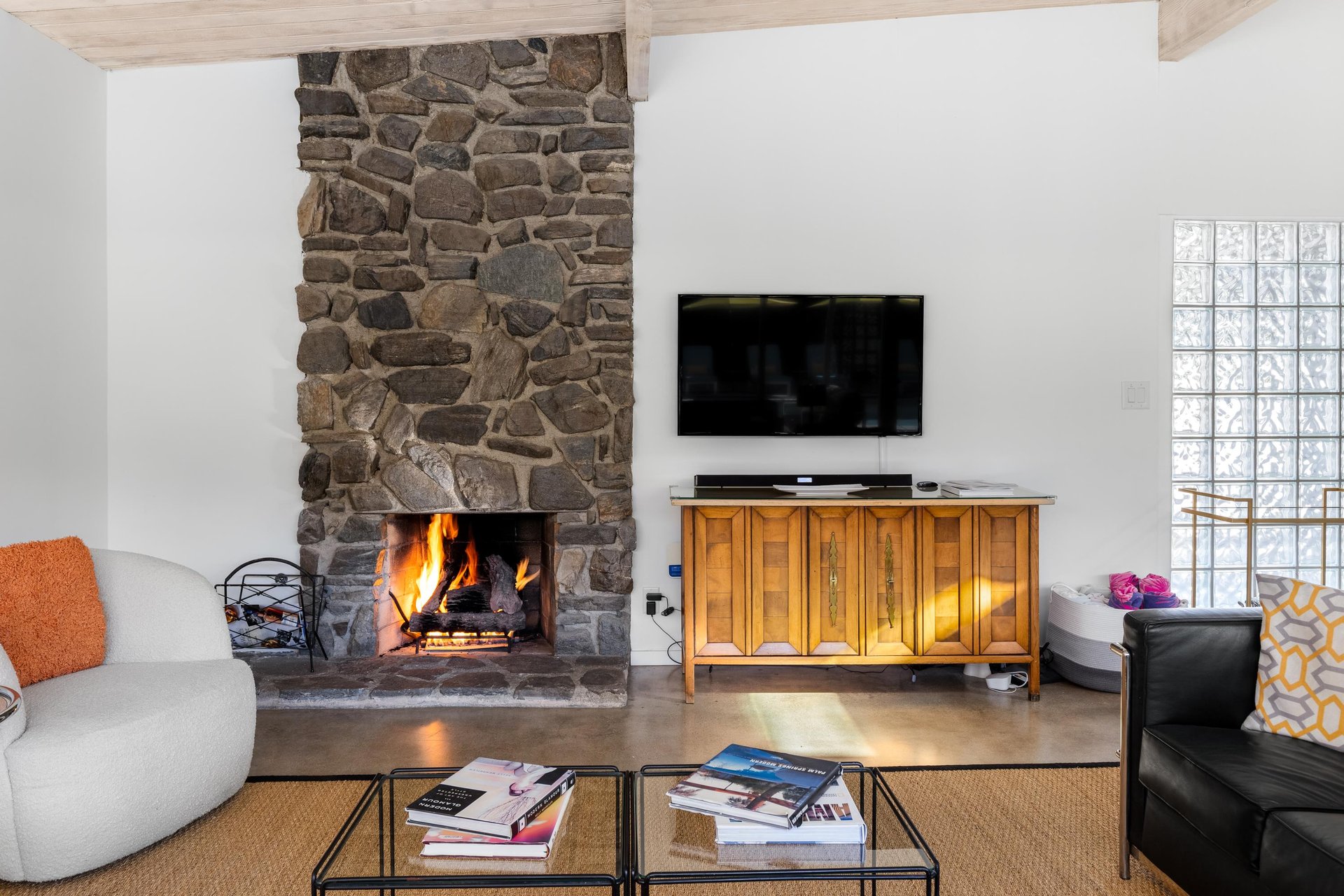 Cozy up by your crackling stone fireplace while enjoying evening entertainment on the flatscreen TV in this inviting living space.