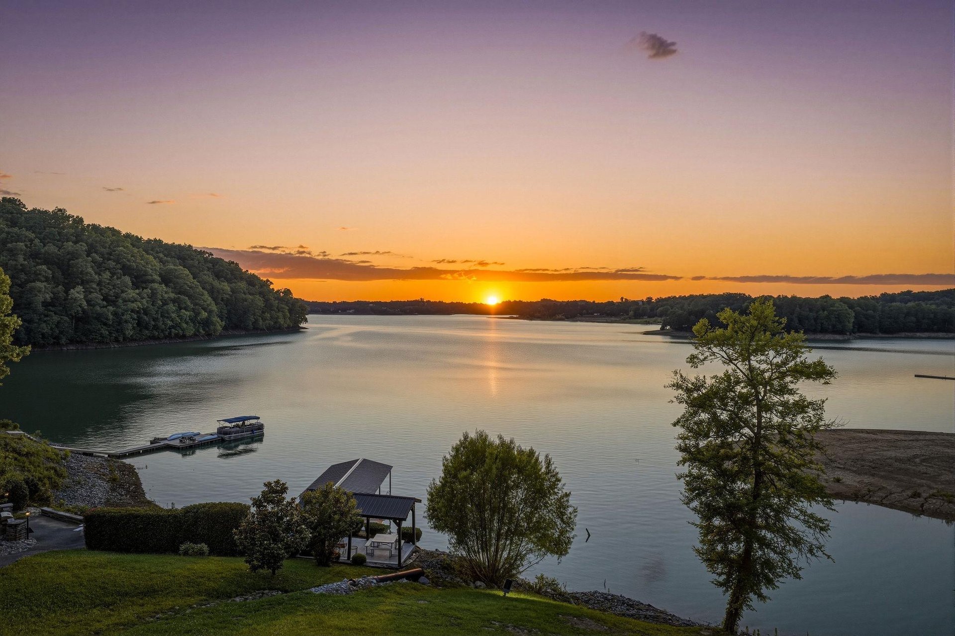 Stunning lakefront property positioned at the waters edge, featuring a private dock and boat slip. Surrounded by dense woodlands and tranquil waters, the setting offers serene natural beauty as the s