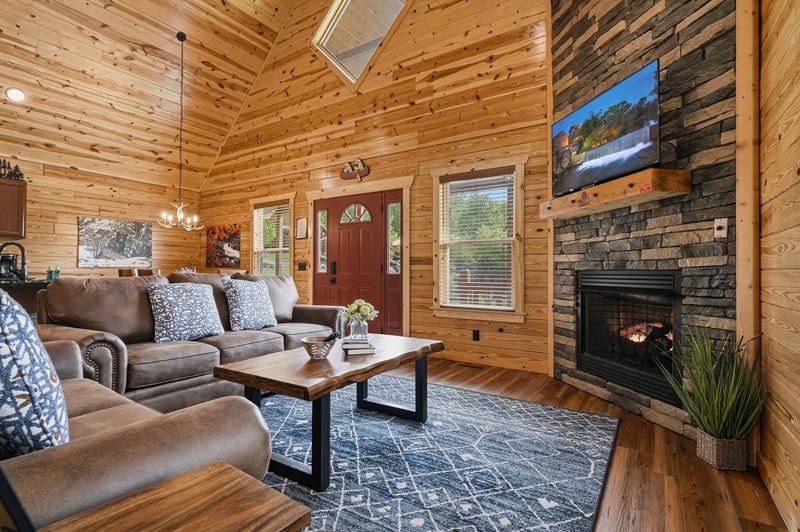 Sink into plush sofas beneath vaulted pine ceilings, where natural light streams through skylights and your mountain getaway truly begins by the warm glow of the stone fireplace.