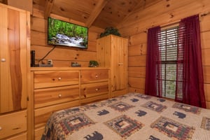 Bedroom with a dresser, armoires, and television at Boogie Bear, a 1bedroom cabin rental located in Gatlinburg