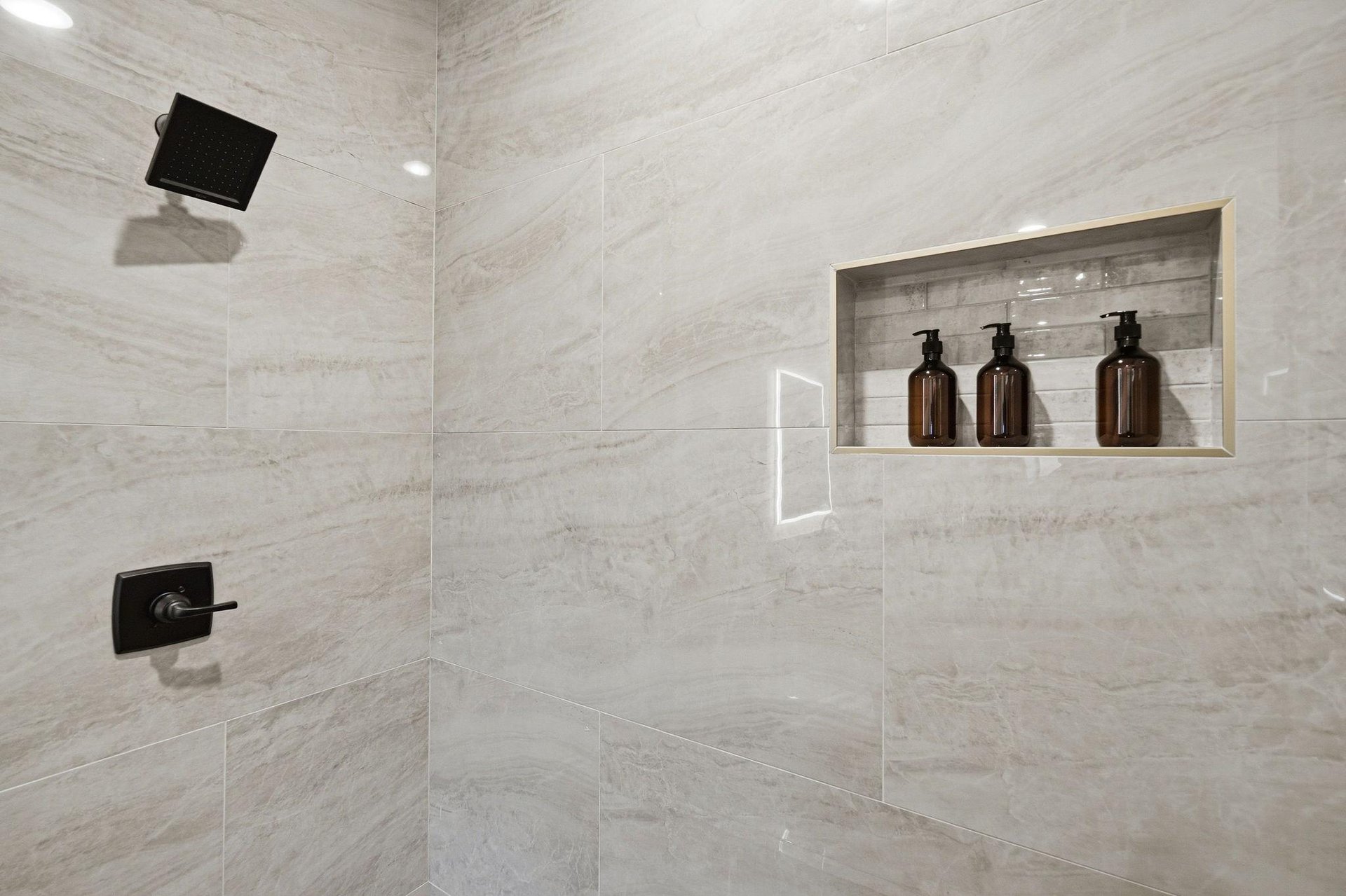 Step into your luxurious marble shower with premium amenities and sleek black fixtures for an indulgent spalike experience.