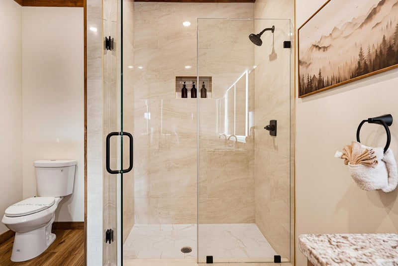 Step into your spacious, spalike bathroom with a glassenclosed shower, elegant fixtures, and thoughtful details like plush towels waiting for you.