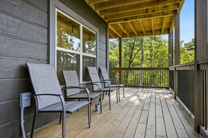 Settle into your private balcony overlooking lush treetops. The covered terrace offers peaceful seating where you can sip morning coffee or unwind as daylight filters through the canopy.