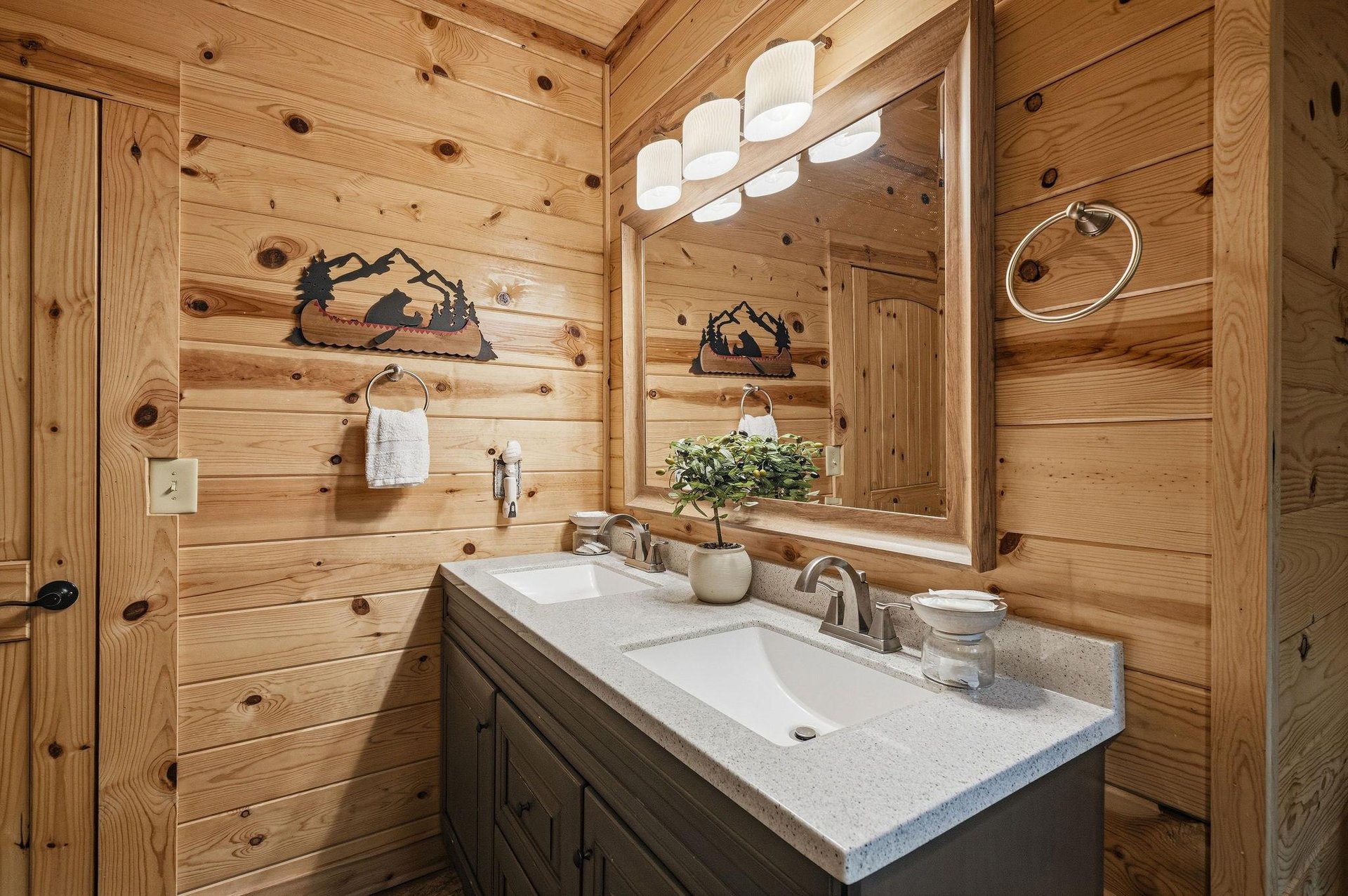 Unwind in your cozy cabinstyle bathroom, where rustic charm meets modern comfort. The double vanity and soft lighting create a welcoming retreat after a day of adventure.