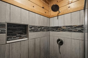 Rinse away the day in your beautifully tiled walkin shower with warm woodpaneled ceiling, thoughtful builtin niche, and modern rainfall showerhead.