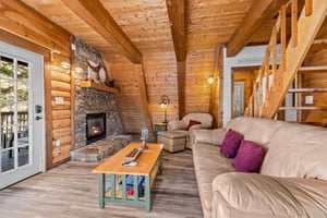 Sofa, fireplace, and chair in the living room at Living on Love, a 2 bedroom cabin rental located in Pigeon Forge