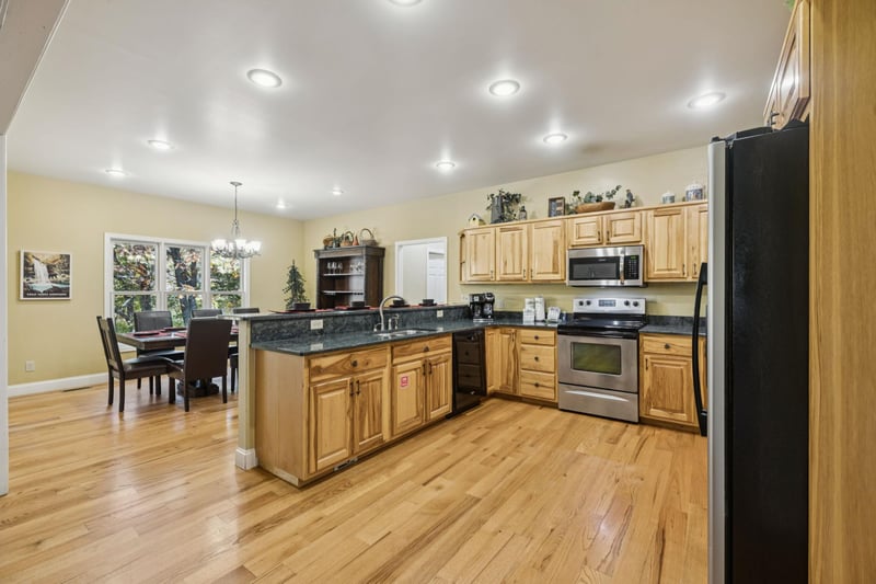 Your spacious kitchen invites you to prepare meals on gleaming granite counters, warmed by natural light streaming through large windows. The open layout flows seamlessly into the dining area, perfect