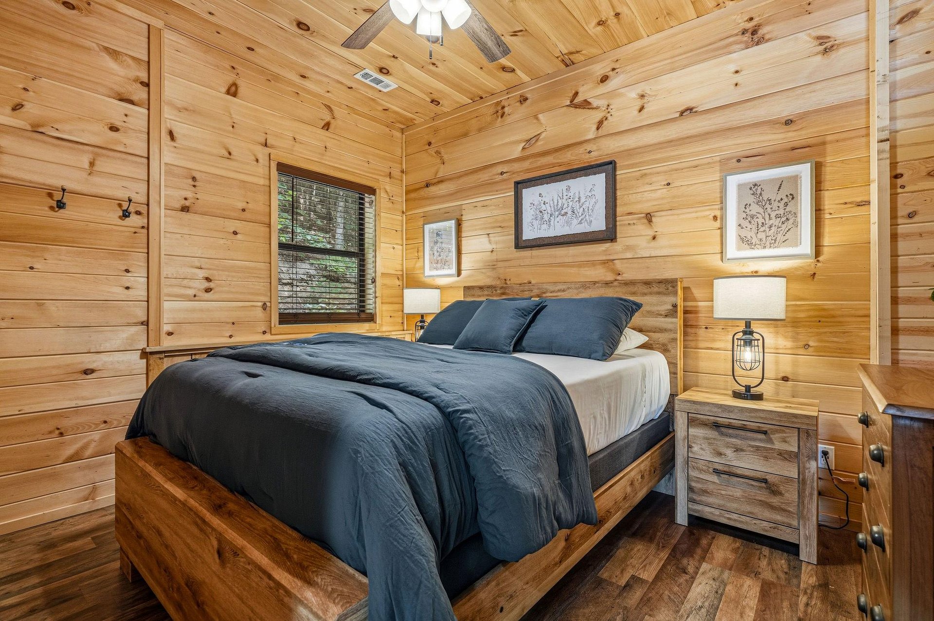 Drift off under warm ceiling lights in this cozy bedroom, where natural pine walls and rustic wood details create your peaceful mountain retreat.
