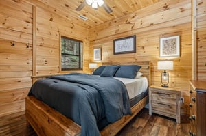 Drift off under warm ceiling lights in this cozy bedroom, where natural pine walls and rustic wood details create your peaceful mountain retreat.