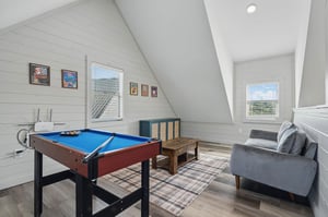 small pool table and sitting area with natural lighting